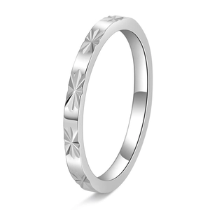 Macro detail of silver faceted ring with engraved star patterns on polished stainless steel