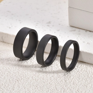 Detailed view of three black matte ceramic rings in 4mm, 6mm, and 8mm widths on stone