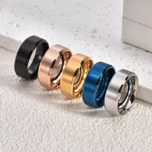 Matte titanium steel ring set in black, gold, and silver on a white stone base