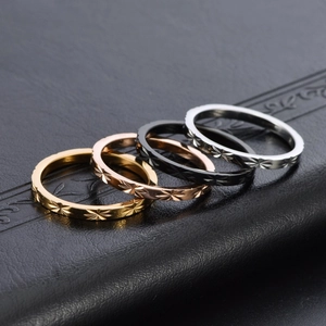 Set of four faceted stackable 18K titanium steel rings in gold, rose gold, black, and silver