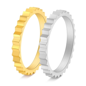 Detail view of gold and silver gear rings with irregular serrated edges and polished finish