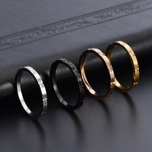 Close-up of four faceted star-patterned stackable rings in silver, black, gold and rose gold