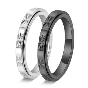 Detail view of rotatable stainless steel rings with engraved star patterns in black and silver