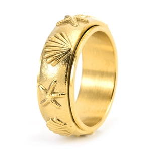 Detailed close-up of rotating gold fidget ring featuring embossed starfish and seashell