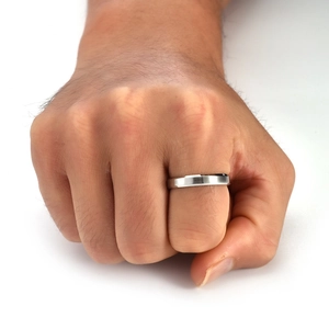 Close-up of minimalist brushed stainless steel band ring on male finger