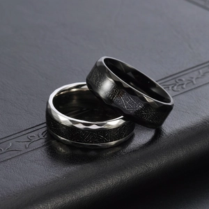 Detailed macro view of black and silver titanium rings with textured rhombus finish