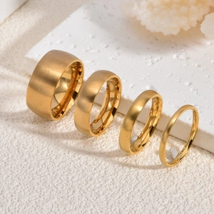 Set of four gold titanium steel rings with brushed finish texture and polished inner walls