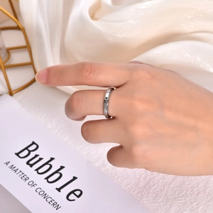 Detailed view of a rotating 3mm stainless steel ring with star pattern on a finger