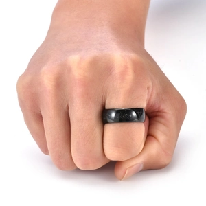 Detail of a matte black tungsten ring with meteorite texture worn on a man's hand