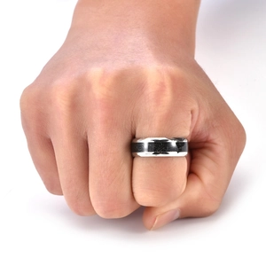 Macro shot of silver titanium ring with textured black inlay worn on a male hand