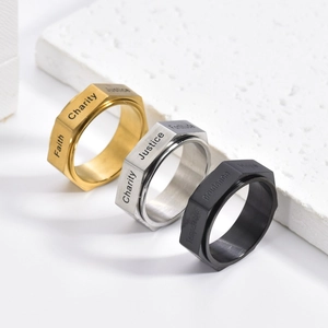 Three hexagonal spinner rings in gold, silver, and black with positive word engravings