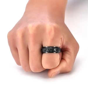 Detail of a rotating titanium steel ring featuring starfish and seashell relief patterns