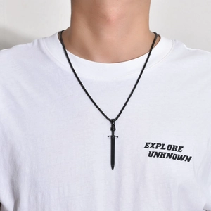 Close-up of a gothic black sword pendant necklace worn on a white t-shirt for men