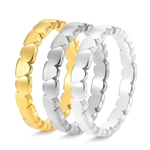 Detailed close-up of stacked heart-shaped rings in polished gold and silver finishes