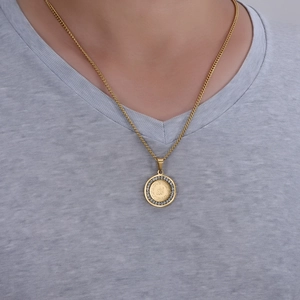 Detail of 18K gold circular Allah pendant with sparkling crystal halo on model