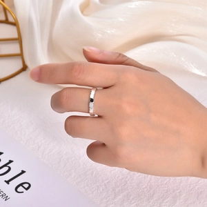 Detail of silver geometric textured stainless steel ring worn on index finger