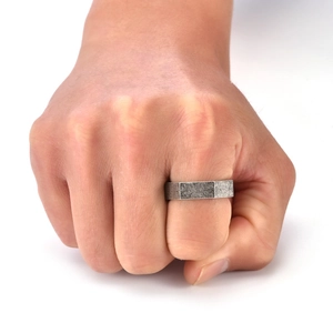 Détail macro d'une bague hexagonale en acier titane brossé au style industriel rétro