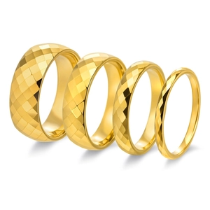 Detailed view of four golden tungsten rings with diamond-cut patterns in varied widths