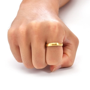 Macro view of gold brushed titanium ring with matte finish on human finger
