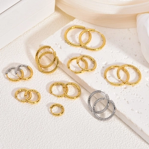Dettaglio macro di varie dimensioni di orecchini a cerchio ritorti oro e argento