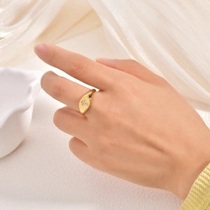 Bague minimaliste en acier titane doré avec croix en strass portée au doigt