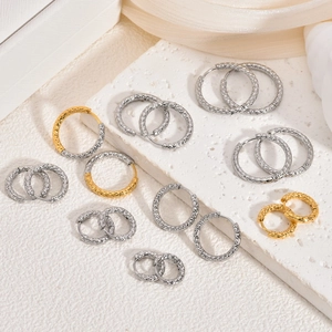 Vue détaillée de créoles texturées en or 18K et argent avec motifs ciselés étincelants