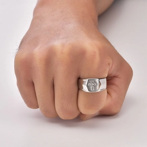 Macro shot of silver stainless steel ring with diamond cross worn on a clenched fist