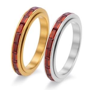 Detail of 18K gold and silver rings with red zircon stones in a full eternity band setting