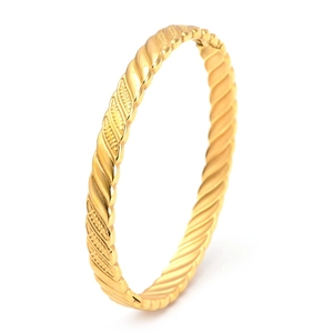 Detailed macro shot of a gold-plated titanium steel bracelet with twisted rope texture