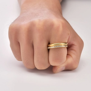 Close-up of stacked 18K gold plated titanium rings with pavé set crystals on a model hand