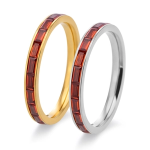 Close-up of gold and silver rings with rectangular red crystal stones in a stack
