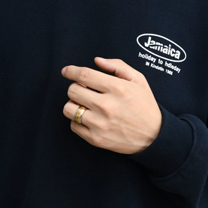 Detail of golden stainless steel Mahjong ring featuring colorful character engravings