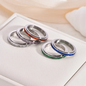 Macro shot of five spinner rings with colorful square-cut zircons and polished finish