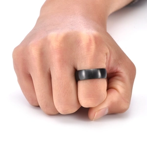 Detail of matte black titanium steel ring with a brushed finish on male finger