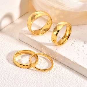 Set of four gold tungsten carbide rings with faceted diamond cut surfaces for men and women