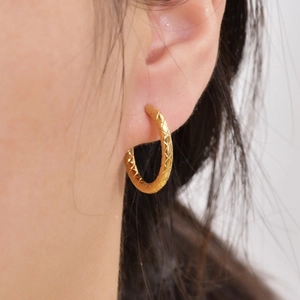 Goldene Creolen mit Rautenmuster am Ohr präsentiert für einen minimalistischen Look