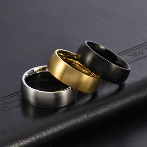 Macro detail of brushed titanium steel rings in silver, gold, and black finishes