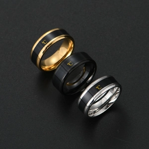 Close-up of smart temperature sensor rings in gold, black and silver titanium steel