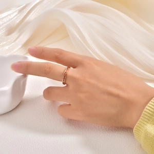Detailed view of a rose gold ring featuring rectangular red crystals on a finger