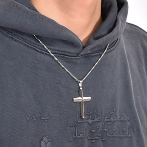 Makroaufnahme des polierten Titanteilstahl-Kreuzanhängers an einer modernen Halskette