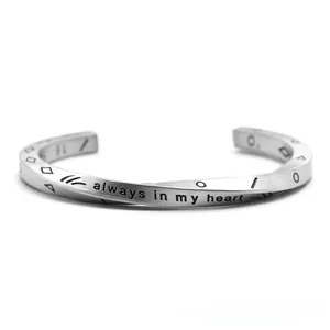 Detail of silver Viking torque bracelet with Mobius twist and engraved heart message