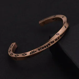 Macro shot of bronze titanium steel cuff featuring always in my heart engraving
