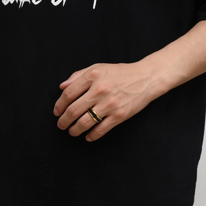 Close-up of a two-tone titanium ring in black and gold on a man's finger