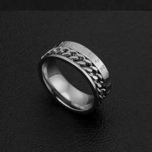 Détail d'une bague rotative argentée avec runes nordiques gravées sur fond de cuir noir