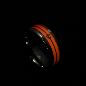 Gros plan d'une bague noire en fibre de carbone pour homme avec motif orange luminescent