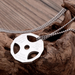Barbell weight plate necklace with engraved motivational quote on rustic wood background