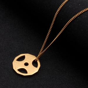Detailed view of golden dumbbell plate pendant with engraved motivational gym quotes