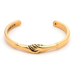 Detailed close-up of golden titanium cuff bracelet with handshake motif and brand engraving
