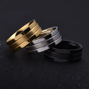 Detail view of three matte stainless steel rings in gold, silver, and black finishes