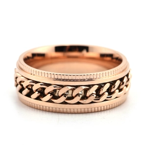 Detail of rose gold spinning chain ring with industrial gear texture and cuban link inlay